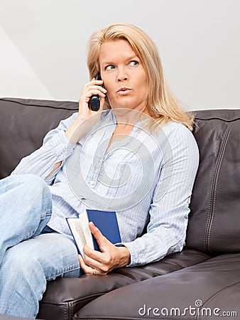 Woman talking on the phone at home Stock Photo