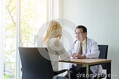 Woman talking to doctor psychiatrist in hospital,Discuss issue and find solutions to mental health problems Stock Photo