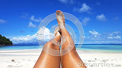 Woman tanned skin legs on the beach. Stock Photo