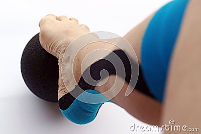 A woman with a tape bandage on her leg does movement exercises Stock Photo