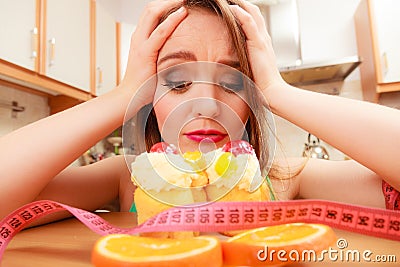 Woman with tape measure and cake. Diet dilemma. Stock Photo