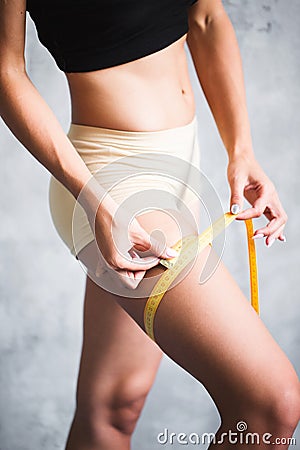 Woman with a tapeline measuring her leg Stock Photo