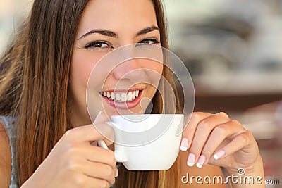 Woman tasting a coffee from a cup in a restaurant terrace Stock Photo