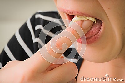 A woman tasting and licking her finger from cake batter and doug Stock Photo