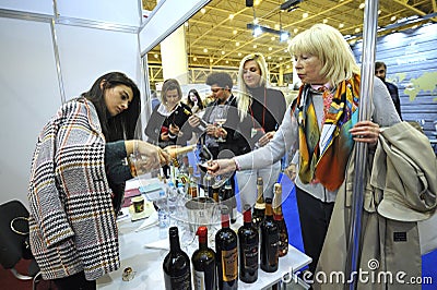 Woman tasting wine at a wine shop, seller standing at a counter Editorial Stock Photo