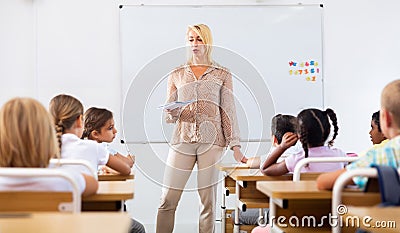 Woman teacher standing at whiteboard during lesson with tweens Stock Photo