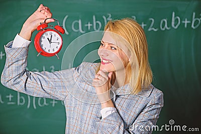 Woman teacher hold alarm clock. Girl school lecturer. What time is it. Lessons schedule. Welcome teacher school year Stock Photo