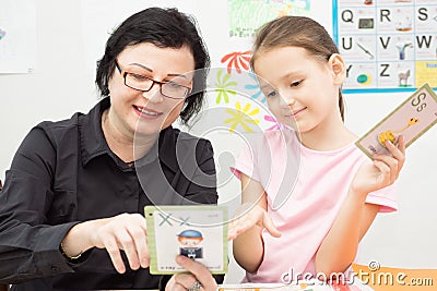 Woman teacher and school girl study with flash cards Stock Photo