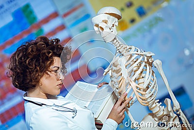 Woman teaching anatomy using human skeleton model Stock Photo