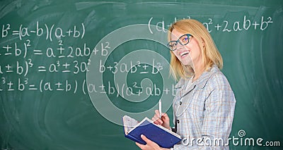 Woman teaching near chalkboard in classroom. Qualities that make good teacher. Effective teaching involve prioritizing Stock Photo