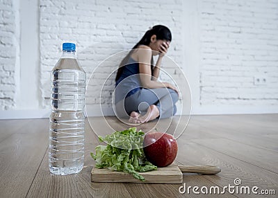 Woman or teenager girl sitting on ground alone worried at home suffering nutrition eating disorder Stock Photo