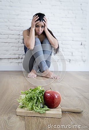 Woman or teenager girl sitting on ground alone worried at home suffering nutrition eating disorder Stock Photo