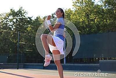 Woman tennis player showing yes gesture after winning point, successful game Stock Photo