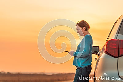 Woman text messaging roadside assistance help after car broke down Stock Photo