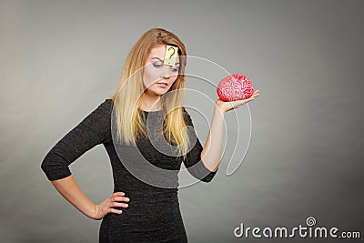 Woman thinking and holding fake brain Stock Photo