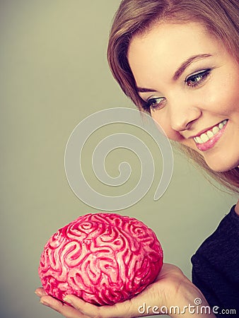 Woman thinking and holding fake brain Stock Photo
