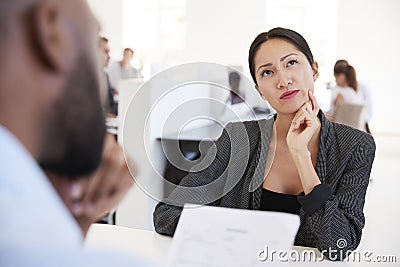 Woman thinking during a job interview in an open plan office Stock Photo