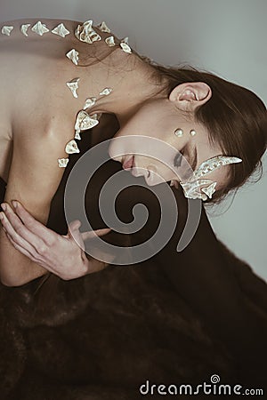 Woman with thorns along back sitting on white background. Elf lost in human world, homesick concept. Tender Stock Photo