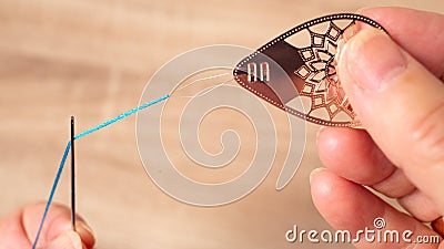 Woman threading needle with threader Stock Photo