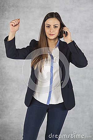 Woman threatens fist during a telephone conversation Stock Photo
