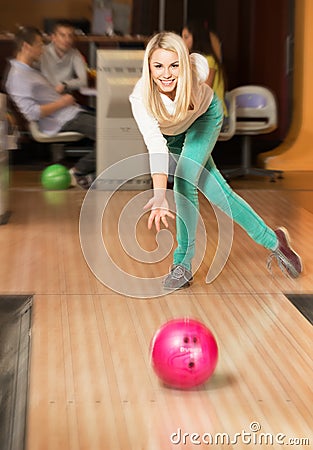 Woman throwing ball in a bowling club Stock Photo