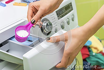 Woman throws laundry detergent into the washing machine. Stock Photo