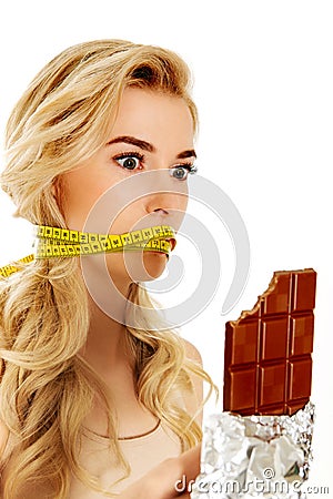 Woman with tied mouth holding bar of chocolate Stock Photo