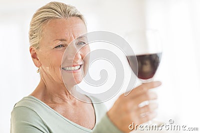 Woman Toasting Red Wineglass At Home Stock Photo