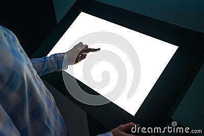 Woman touching interactive white blank touchscreen display kiosk at exhibition Stock Photo