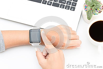 Woman touching smart watch hand on work table Stock Photo