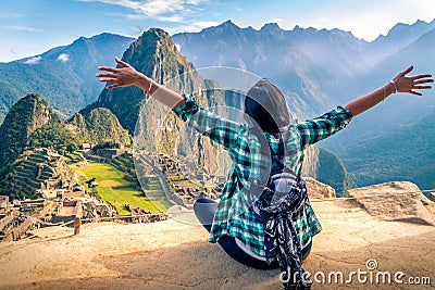 A woman tourist contemplating the amazing landscape of Machu Picchu with arms open Stock Photo