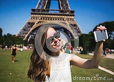 Woman tourist at Eiffel Tower smiling and making Stock Photo