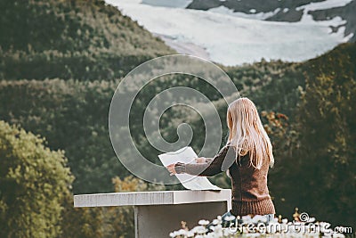 Woman tourist holding map planning route trip in Norway sitting at the table Travel Lifestyle Stock Photo