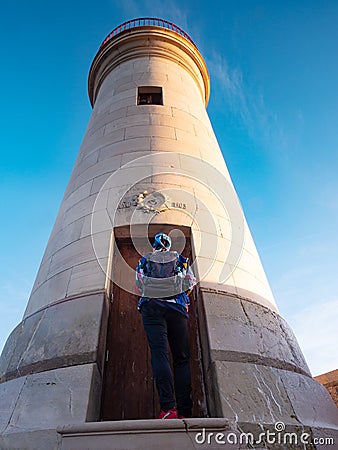 Woman tourist is knocking on lighthouse door Stock Photo