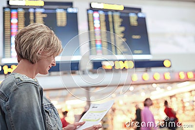 Woman tourist looking at timetable in airport Stock Photo