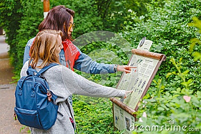 Woman tourist reading information board sign with short info about animal species in the Berlin Zoo Editorial Stock Photo