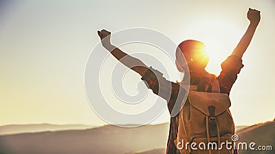 Woman tourist at top of mountain at sunset outdoors during hike Stock Photo