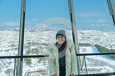 Woman tourist Visiting in Hakodate, Traveler in Sweater sightseeing view from Goryokaku Tower with Snow in winter. landmark and Stock Photo