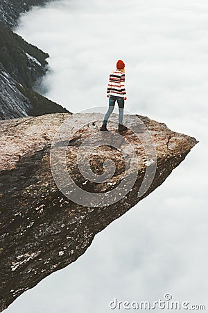 Woman tourist walking on Trolltunga rocky cliff Stock Photo