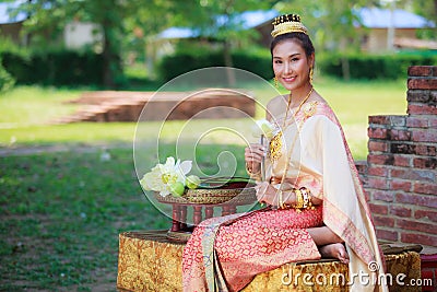Woman in traditional clothes fold lotus flower petals used in rituals of Buddhism religion. A Lotus represents purity of body Stock Photo