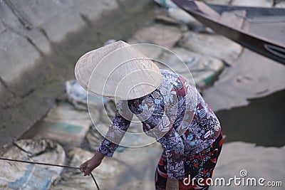 A woman in a straw hat measures the level of sea water Stock Photo