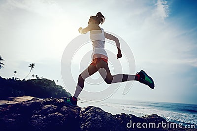 woman trail runner running to rocky mountain top Stock Photo