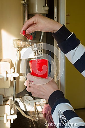 A woman on the train carefully pours boiling water Stock Photo