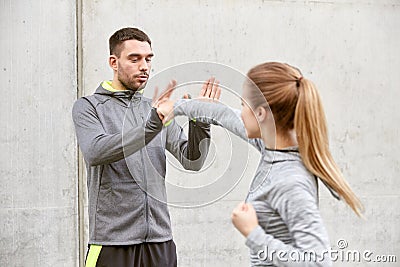 Woman with trainer working out self defense strike Stock Photo