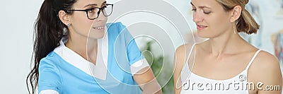 Woman traumatologist doctor in blue suit holds young patient by knee in clinic office portrait Stock Photo