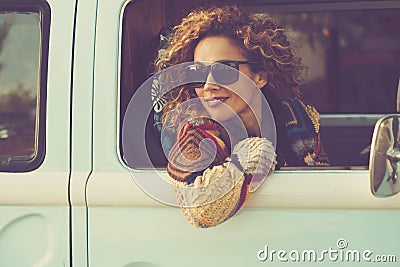 Woman travel with vehicle and looking outside the window smiling and enjoying road trip alone. Concept of classic van renting Stock Photo