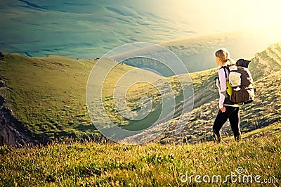 Woman Traveler with Backpack hiking in Mountains Stock Photo