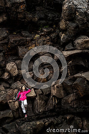 Woman traveler on rocky ridge in Hellnar, Iceland. Stock Photo