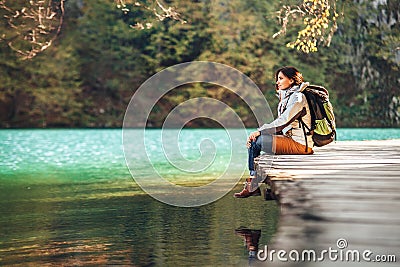 Woman traveler sits on wood bridge and looks calm on mountain la Stock Photo