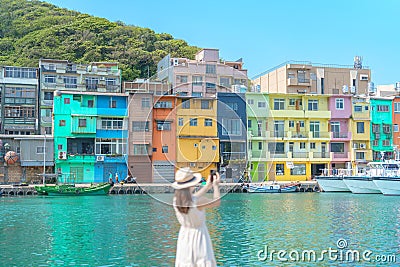 woman traveler visiting in Taiwan, Tourist taking photo by smartphone and sightseeing in Keelung, Colorful Zhengbin Fishing Port, Stock Photo